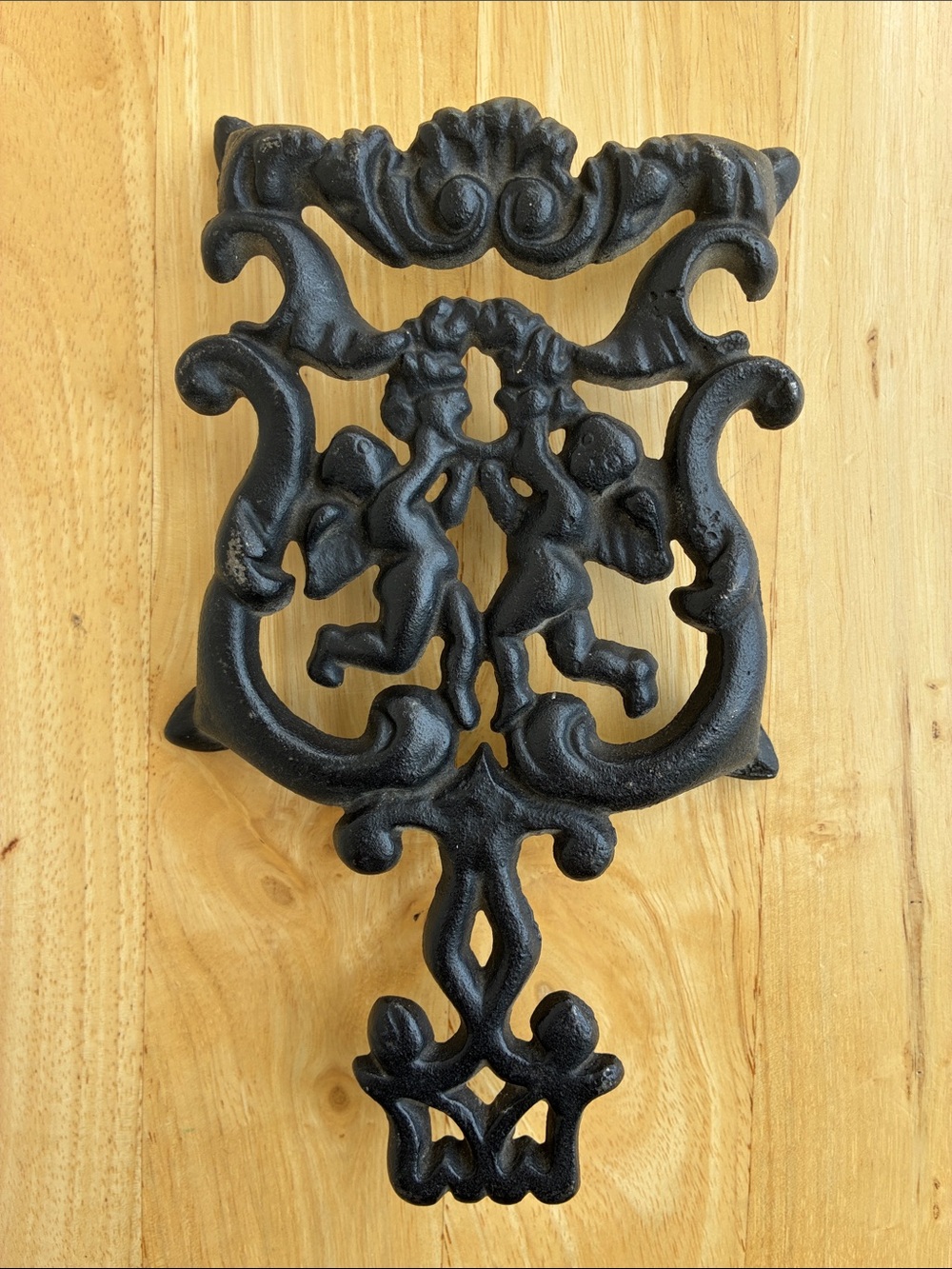 Black Cast Iron Trivet. Ornate Cherub Design. Almost 8 inches